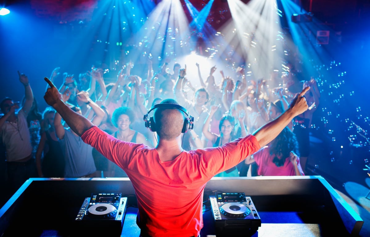 DJ performing at a Las Vegas nightclub with crowd under lights